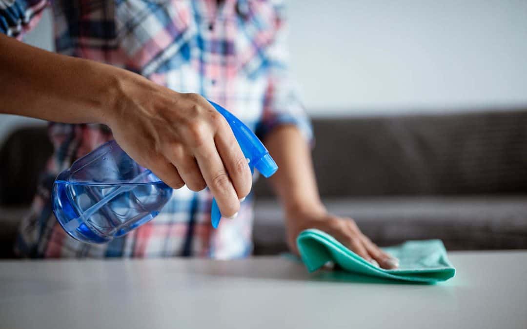 Keep your storage unit clean, man spraying item in storage unit to remove dust